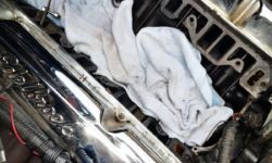AMC 360 V8-Motor beim CJ7 - Revidieren der Hydro-Stösselstangen und Umbau auf Edelbrock Ansaugbrücke mit original Guss-Krümmer. // Hier: Neue Edelbrock Chrom-Ventildeckel